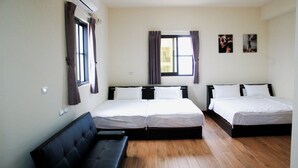 A hotel room with two beds, a sofa, and a window with curtains. - Eliza Inn (Magong)