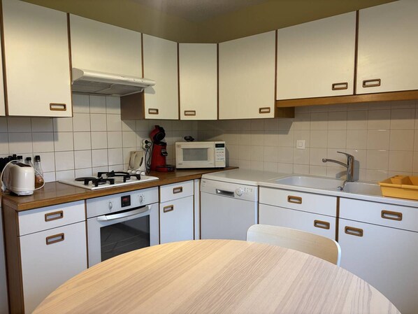 Efficient kitchen with microwave, stove, and dishwasher.