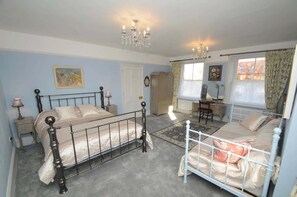 A bedroom with a double bed, a desk, a chair, a wardrobe, and a chandelier. - The Quays Christchurch Dorset (Christchurch)