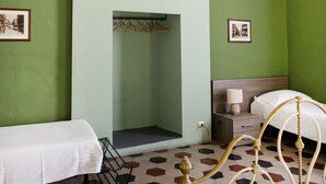Habitación de hotel con dos camas, un televisor montado en la pared y un suelo con un diseño hexagonal único.