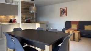 Una cocina moderna con comedor, sofá y cafetera.