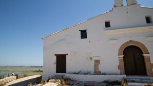A white building with a bell tower and arched doorway, set against a clear sky. - Big Terrace Apartment Cullera (Cullera)