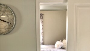 Una camera da letto con un letto, un termosifone e una sveglia a muro.