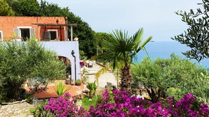 A coastal villa with a patio, outdoor seating, and a view of the sea. - La BouganVilla Charme & Relax with sea view (finale ligure)
