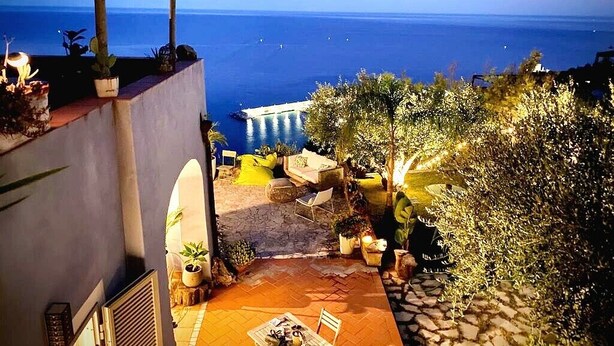 A terrace with a view of the sea, outdoor seating, and potted plants. - La BouganVilla Charme & Relax with sea view (finale ligure)
