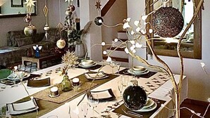 A dining area with a long table set for a meal, featuring various decorative items and a unique chandelier. - La BouganVilla Charme & Relax with sea view (finale ligure)