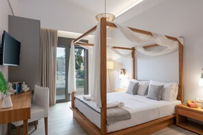 Een moderne slaapkamer met een hemelbed, een bureau en een televisie.