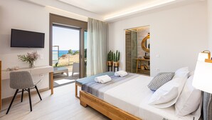 Ein modernes Hotelzimmer mit Bett, Schreibtisch, Stuhl und Fernseher.