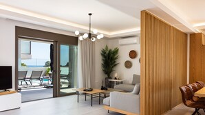 Ein modernes Wohnzimmer mit Sofa, Couchtisch und Essbereich. Es gibt einen Fernseher, eine Pflanze und einen Blick ins Freie.