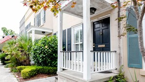 A two-story house with a porch, a black front door, and a mailbox.