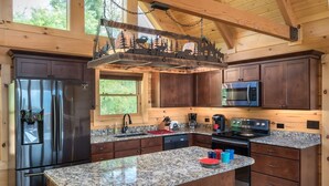 A modern kitchen with granite countertops, stainless steel appliances, and wooden cabinetry. - Four Bears: Amazing View, Private, Arcade, Screened in Porch with Wood Burning (Gatlinburg)