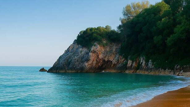 Una platja amb aigua turquesa cristal·lina, sorra daurada i un penya-segat rocos amb vegetació.