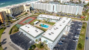 Luftaufnahme eines Hotels mit mehreren Gebäuden, einem Schwimmbad und einem Parkplatz.