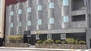 Un hôtel doté d’une architecture moderne, caractérisé par une façade en pierre et de nombreuses fenêtres.