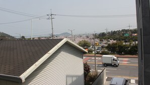 Une vue d’une rue avec un immeuble blanc, un camion et des lignes électriques.