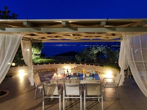 Enjoy al fresco dining under a charming pergola with a table set for four.