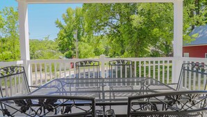 A covered patio with a metal table and chairs, surrounded by a white fence, overlooking a green landscape. - Frene Valley Guest House (Hermann)