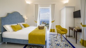 Une chambre d’hôtel avec un grand lit, une chaise, un bureau et un téléviseur.