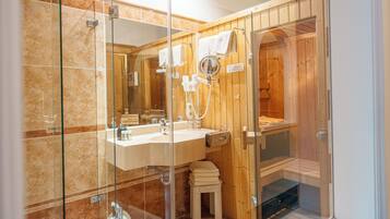 Un baño moderno con ducha acristalada, un espejo grande y un mueble de tocador de madera.