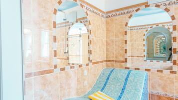 Enjoy a room with a large window offering a view of the sky, a tiled floor, and a comfortable bed with a striped bedspread.