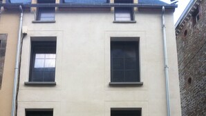 A multi-story building with a flat facade, several windows, and a garage entrance. - VILLA with garage and terrace 200 ml beaches parks and shops (Saint-Malo)