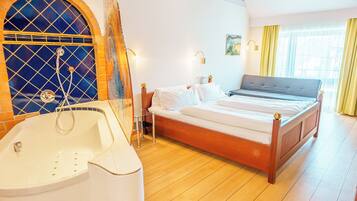 Une chambre avec un grand lit, une baignoire et un mur décoratif.