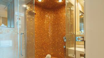 Een moderne badkamer met een douchecabine van glas, een zichtbaar toilet en een wastafel.