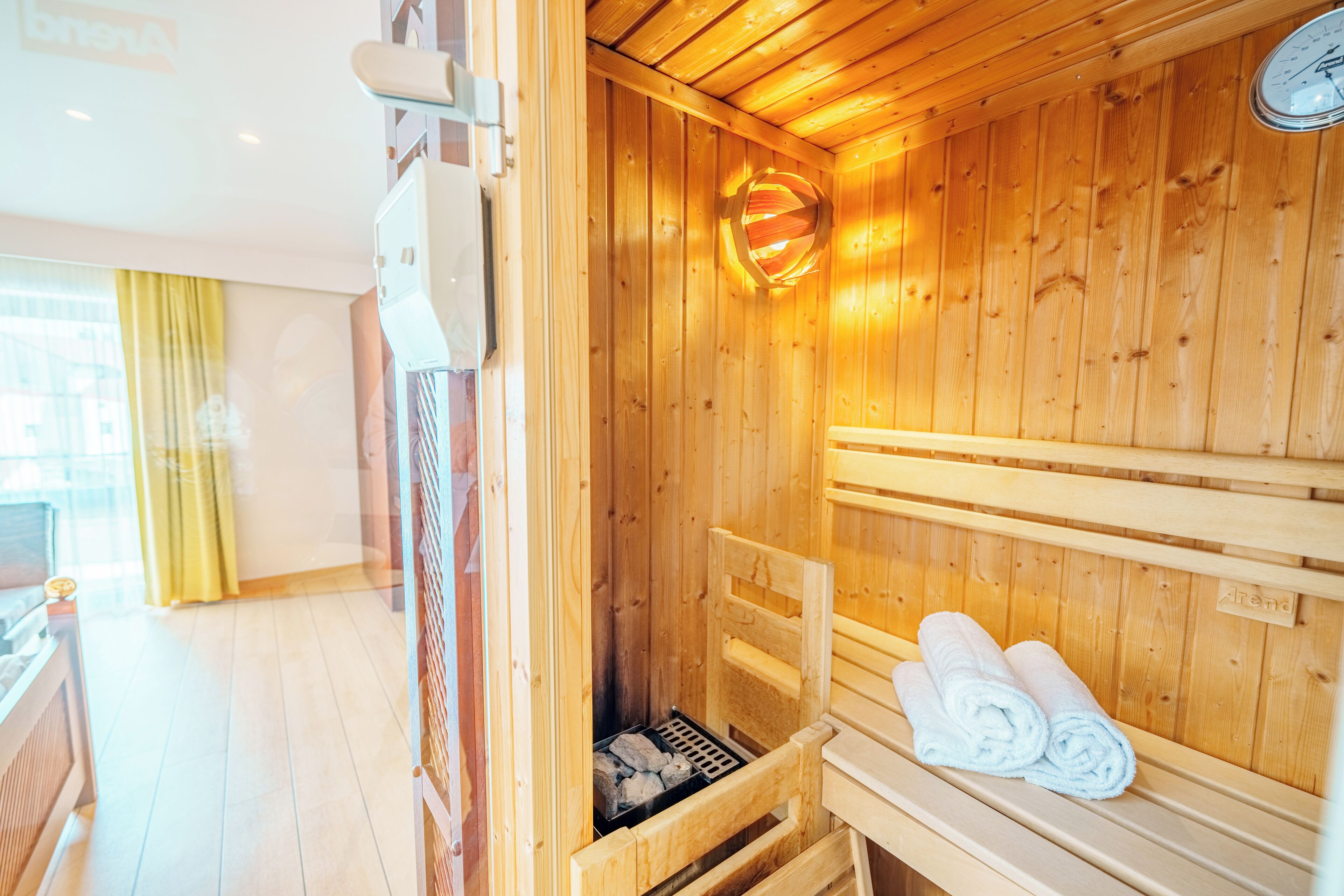 A wooden sauna room with benches and a towel rack.