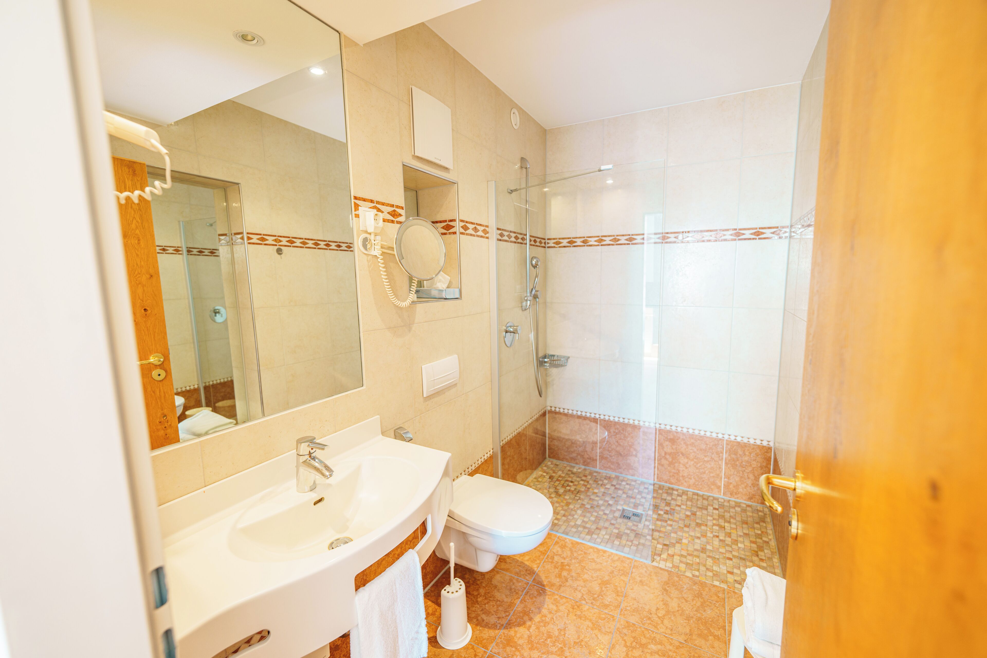 A bathroom with a sink, toilet, and shower.