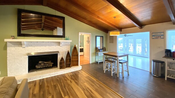 A spacious living room with a fireplace, wooden flooring, and a high ceiling. - Relax on Lake Bowen at our spacious 3-bedroom retreat (Inman)