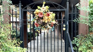 Een poort met een decoratieve bloemarrangement dat eraan hangt.