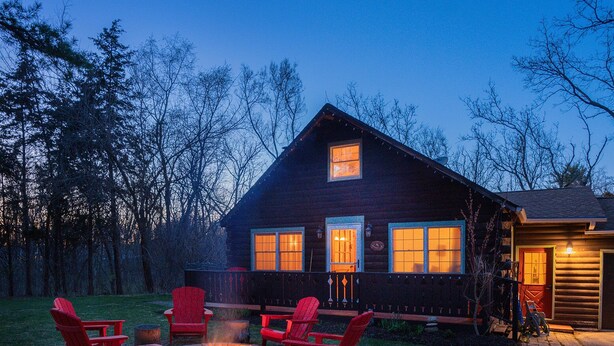 A log cabin with a fire pit and red Adirondack chairs in the yard. - Northwoods of Lake Geneva. Pet-Friendly! (Williams Bay)