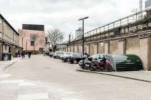 A street with parked cars and a green dumpster. - Beautifully Presented 2BD Flat near Westminster (London)