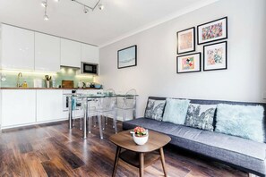 Ein modernes Wohnzimmer mit Küche, Essbereich und Sitzgelegenheit.