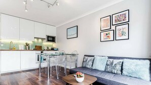 Ein modernes Wohnzimmer mit Küche, Essbereich und Sitzgelegenheit.