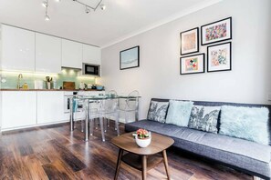 Ein modernes Wohnzimmer mit Küche, Essbereich und Sitzgelegenheit.