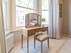 A room with a wooden vanity, a bench, a mirror, and a view of the outside through large windows. - Inviting 2BD Victorian Flat, Near Hampstead (London)