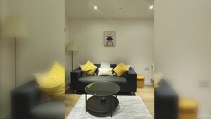 Een woonkamer met een bank, een salontafel en een lamp.