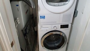 Eine kompakte, weiße, 2-türige Waschmaschine mit einer Frontlade-Trommel und einem kleineren, separaten Wäschetrockner.