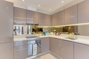 A modern kitchen with a built-in oven, a microwave, and a sink.