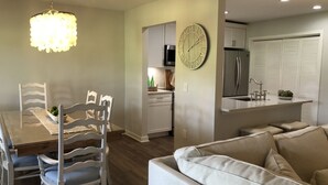 A modern kitchen with white cabinetry, a built-in oven, and a refrigerator.