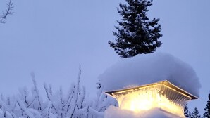 Een besneeuwde buitenruimte met een lamp op een pilaar.