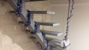 A staircase with a white handrail and blue tinsel garland. - Charming apartment in the escutcheon (Montpellier)