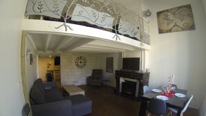 A spacious living room with a fireplace, a dining area, and a sofa. - Charming apartment in the escutcheon (Montpellier)