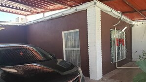 A black car parked in front of a building with a brown wall and white trim. - BONITA CASA CENTRO MTY KIKE (monterrey)