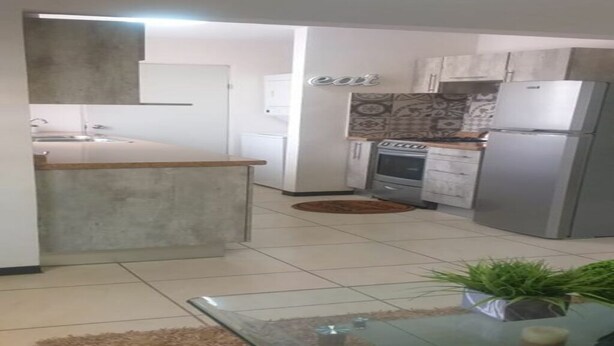 A modern kitchen with a central island, a built-in oven, and a refrigerator. - BONITA CASA CENTRO MTY KIKE (monterrey)