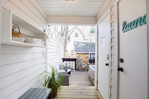 outdoor space accessible through a covered corridor with a wooden deck floor.