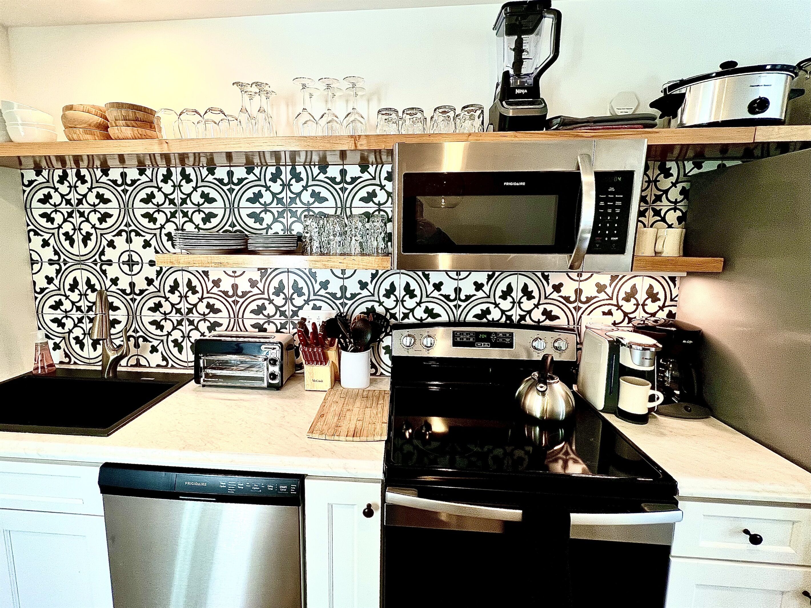 A kitchen with a microwave, toaster, kettle, and coffee maker.