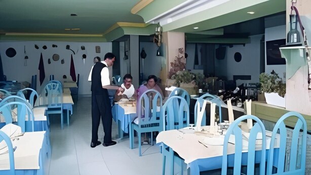 A restaurant with blue chairs and tables, a waiter, and a customer seated. - Hotel Sindbad Center Sousse (Sousse)