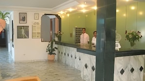 A reception area with a marble floor, a reception desk, and framed pictures on the wall. - Hotel Sindbad Center Sousse (Sousse)